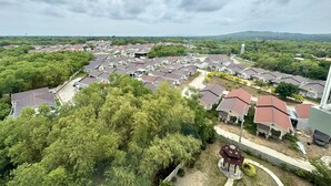 Un quartiere residenziale con diverse case, un gazebo e una torre dell'acqua in lontananza.