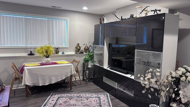 En matplats med ett bord dukat för två personer, en tv och dekorativa föremål.