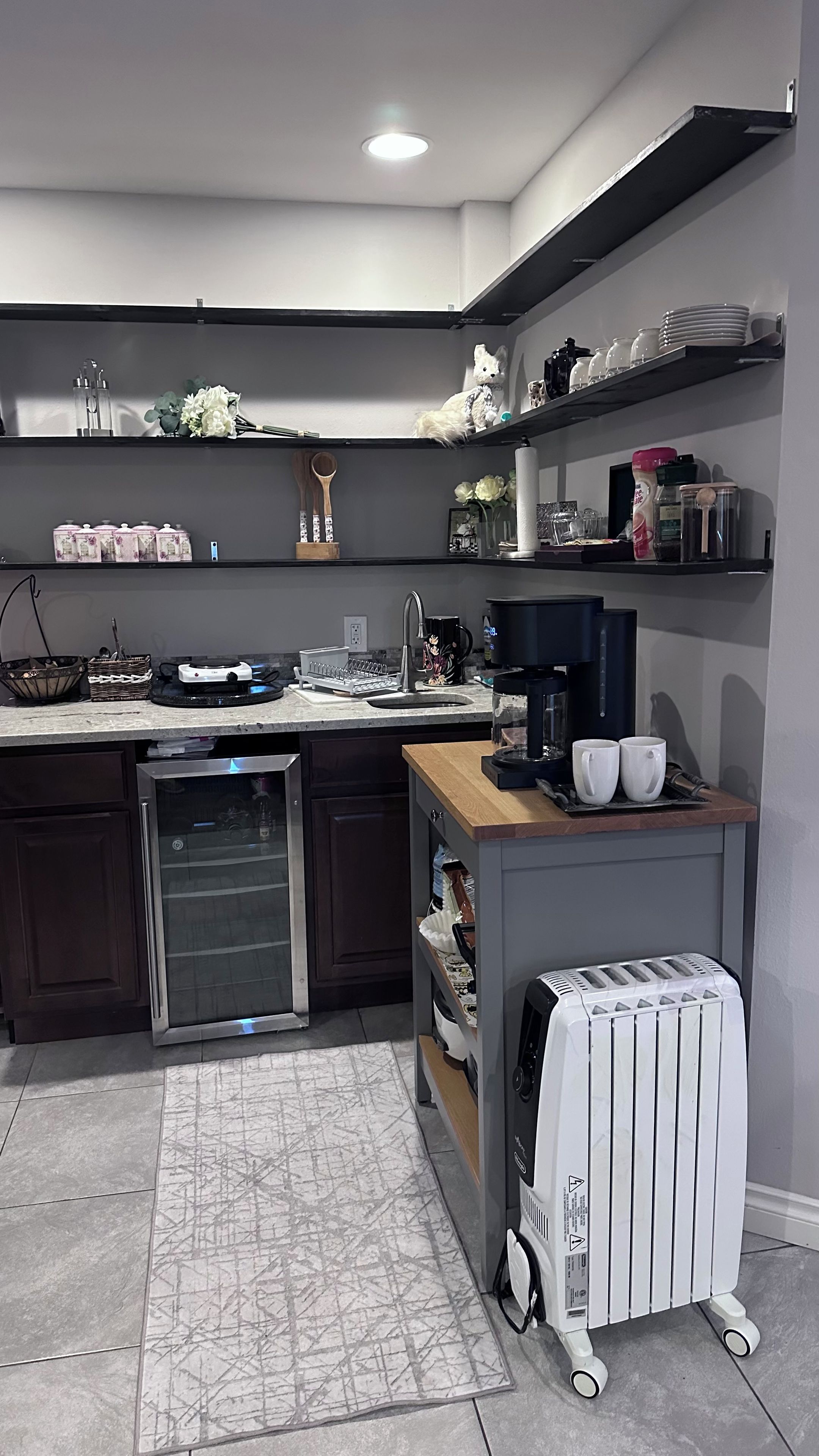 Una cocina moderna con lavavajillas integrado, cafetera y tostadora sobre una encimera de madera.
