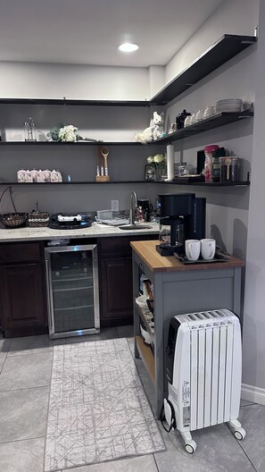 A modern kitchen with a built-in dishwasher, a coffee maker, and a toaster on a wooden countertop.
