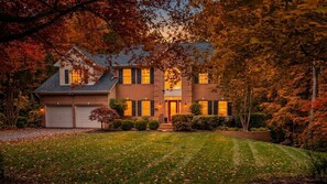 A two-story house with a brick facade, a front porch, and a well-maintained lawn. - Cozy 5-Bed Retreat, Heated Spa (Port Republic)