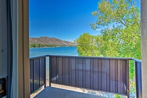 Varanda com vista para um lago e montanhas.
