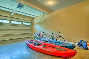 Uma garagem com caiaques e bicicletas guardadas lá dentro.