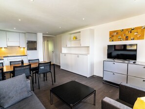A modern apartment with a dining area, kitchen, living room, and a TV. - Sportina 13 1. OG Süd-West Appartement/Fewo, Bad, WC by Interhome (Riederalp)
