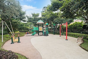 A playground with a slide, swings, and a climbing structure. - Anaya Villa by Kozystay - Paskal (Bandung)
