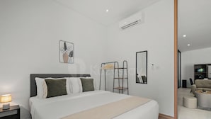 Una moderna camera d'albergo con un letto grande, un comodino e un armadio.