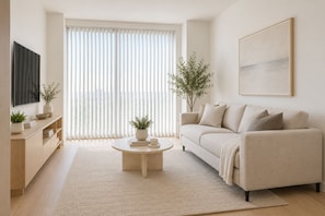 Una sala de estar moderna con un sofá, una mesa de centro y plantas en macetas.