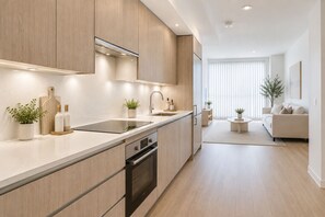 Una cocina moderna con horno empotrado, un lavamanos y una encimera con plantas en macetas.
