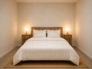 A neatly made bed with a wooden headboard, two bedside tables with lamps, and a plain wall. - CBD Darwin 1-bed Stay With Free Parking (Darwin)
