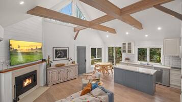A spacious living area with a fireplace, a large TV, and a cozy seating area.