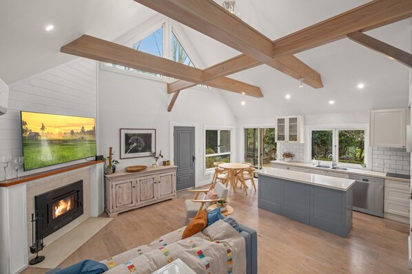 A spacious living area with a fireplace, a large TV, and a cozy seating area.