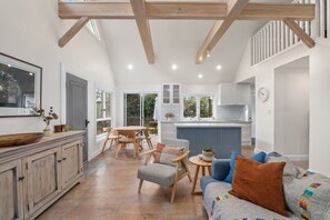 Un amplio espacio de sala con una mesa de comedor, un sofá y una cocina al fondo.