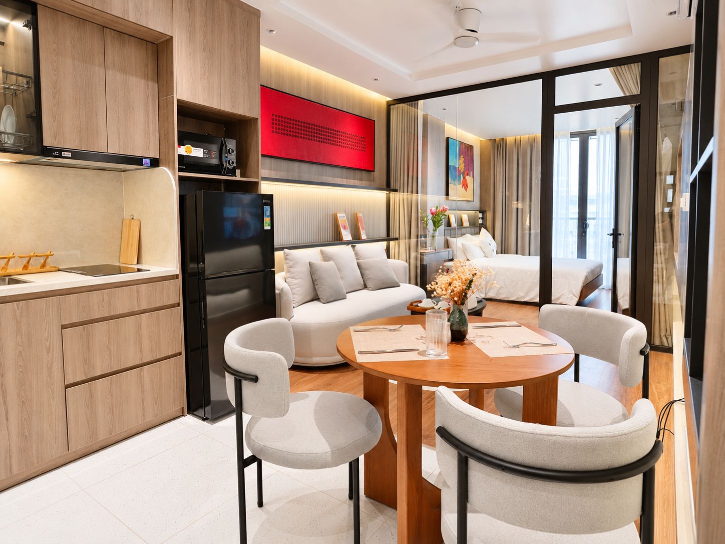 Une chambre d’hôtel moderne dotée d’un coin cuisine, d’une table à manger avec des chaises, d’un canapé et d’un lit.