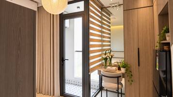 A modern kitchen with a built-in refrigerator, a dining table with chairs, and a large window with blinds.