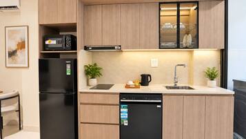 A modern kitchen with a refrigerator, dishwasher, microwave, and a sink with a faucet.