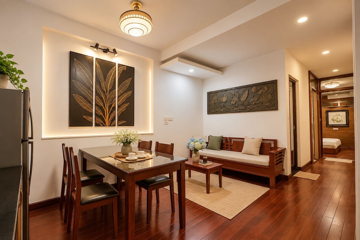 A modern living room with a dining area, wooden flooring, and artwork on the walls.