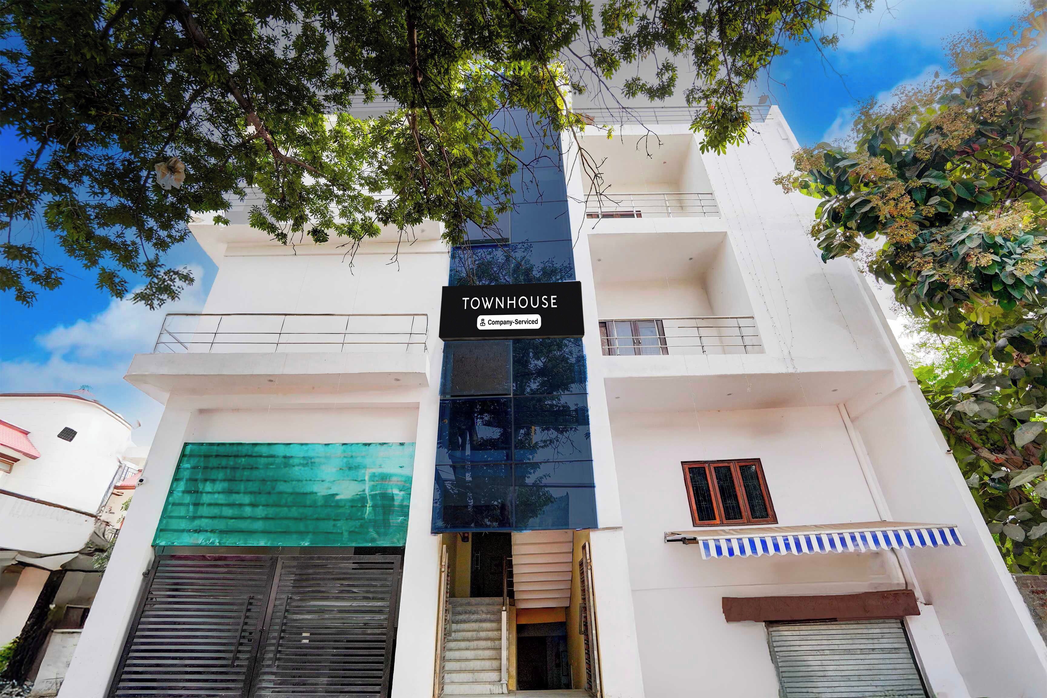 Un edificio de varios pisos con un cartel que indica que se trata de una casa adosada con servicios de empresa.