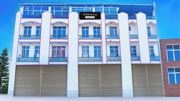 Um edifício de vários andares com uma placa indicando que é uma casa geminada com serviços para empresas.