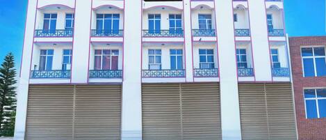 Un immeuble à plusieurs étages, sur lequel on peut lire une enseigne indiquant qu’il s’agit d’une maison de ville gérée par une entreprise.