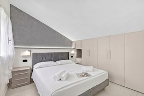 A modern bedroom with a bed, bedside tables, and a wardrobe. - Sant'eufemia 14 (Modena)