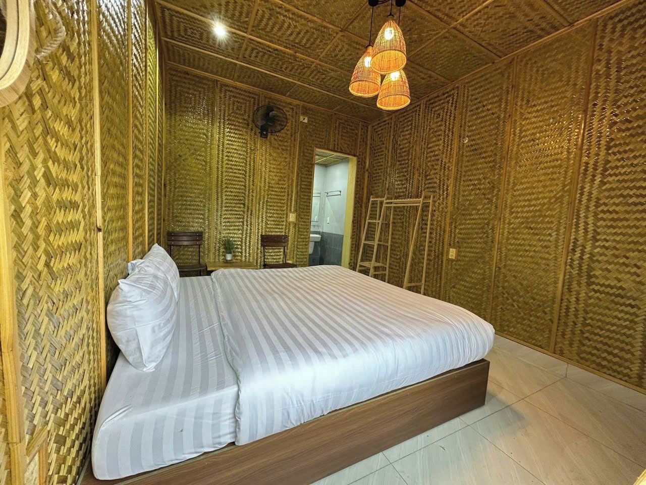 A room with a bed, a wooden floor, and a textured wall.