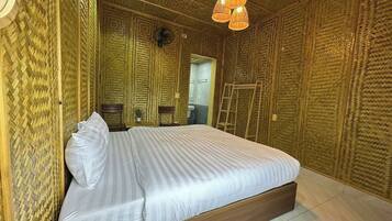 A room with a bed, a wooden floor, and a textured wall.