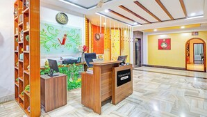 A reception area with a reception desk, computer, and a clock on the wall. - Townhouse Seethammadhara Junction (Visakhapatnam)