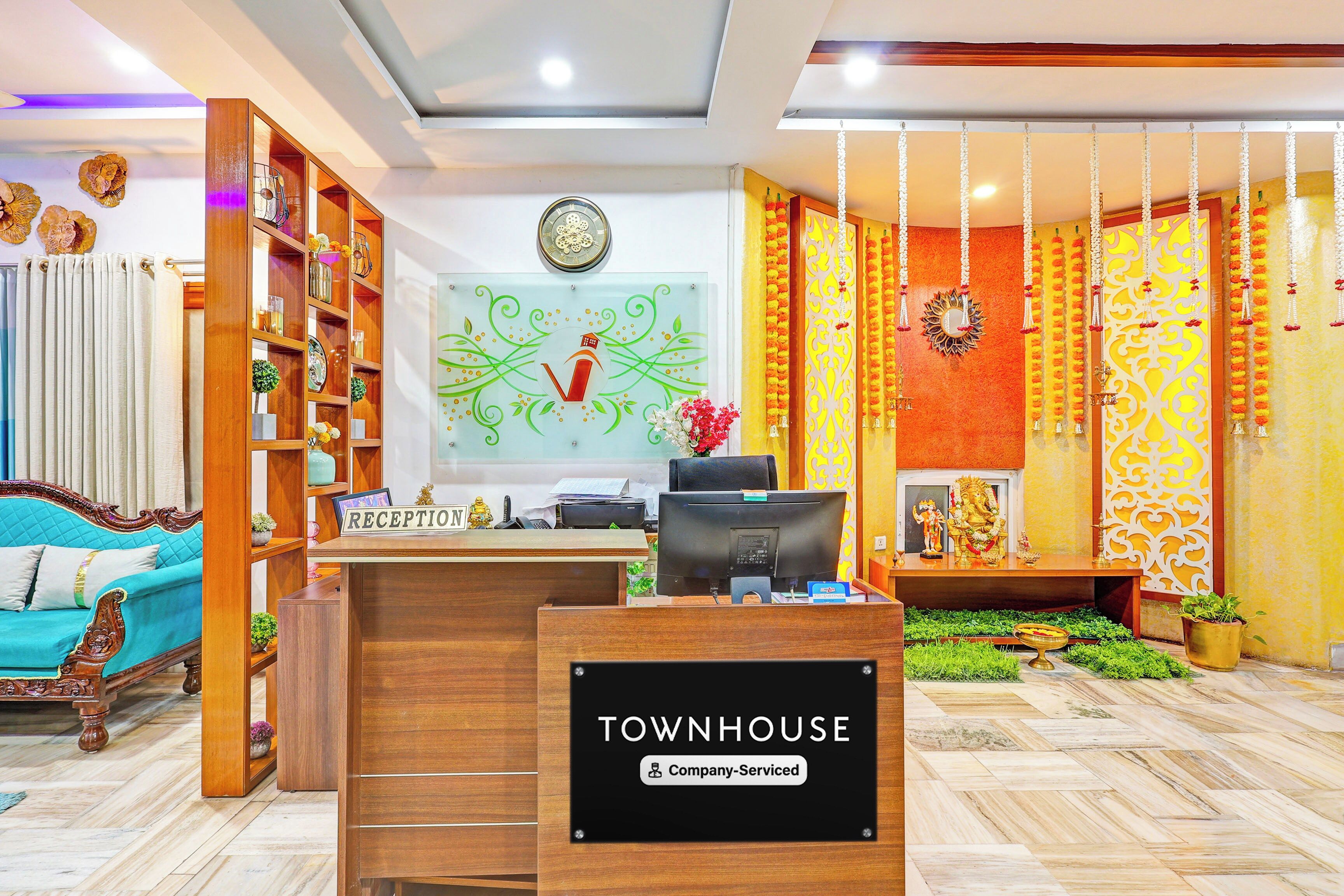 A reception area with a reception desk, a clock, and a sign indicating 'Company-Serviced'.