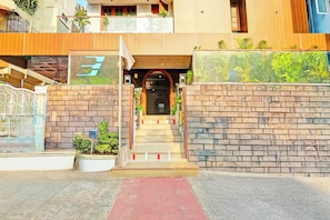 A residential building with a staircase leading to a door, a gated entrance, and a small garden area. - Townhouse Seethammadhara Junction (Visakhapatnam)