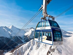 A cable car with 'Samsnau' and 'Berghaben' labels, suspended over a snowy mountain landscape. - Haus am Brunnen, (Samnaun-Compatsch) by Interhome (Samnaun)