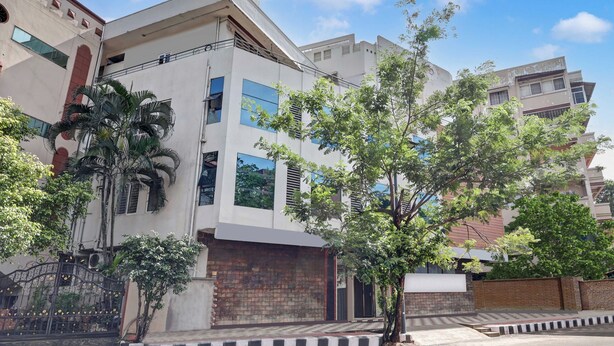 Un edificio moderno con techo plano, amplias ventanas y base de ladrillo.