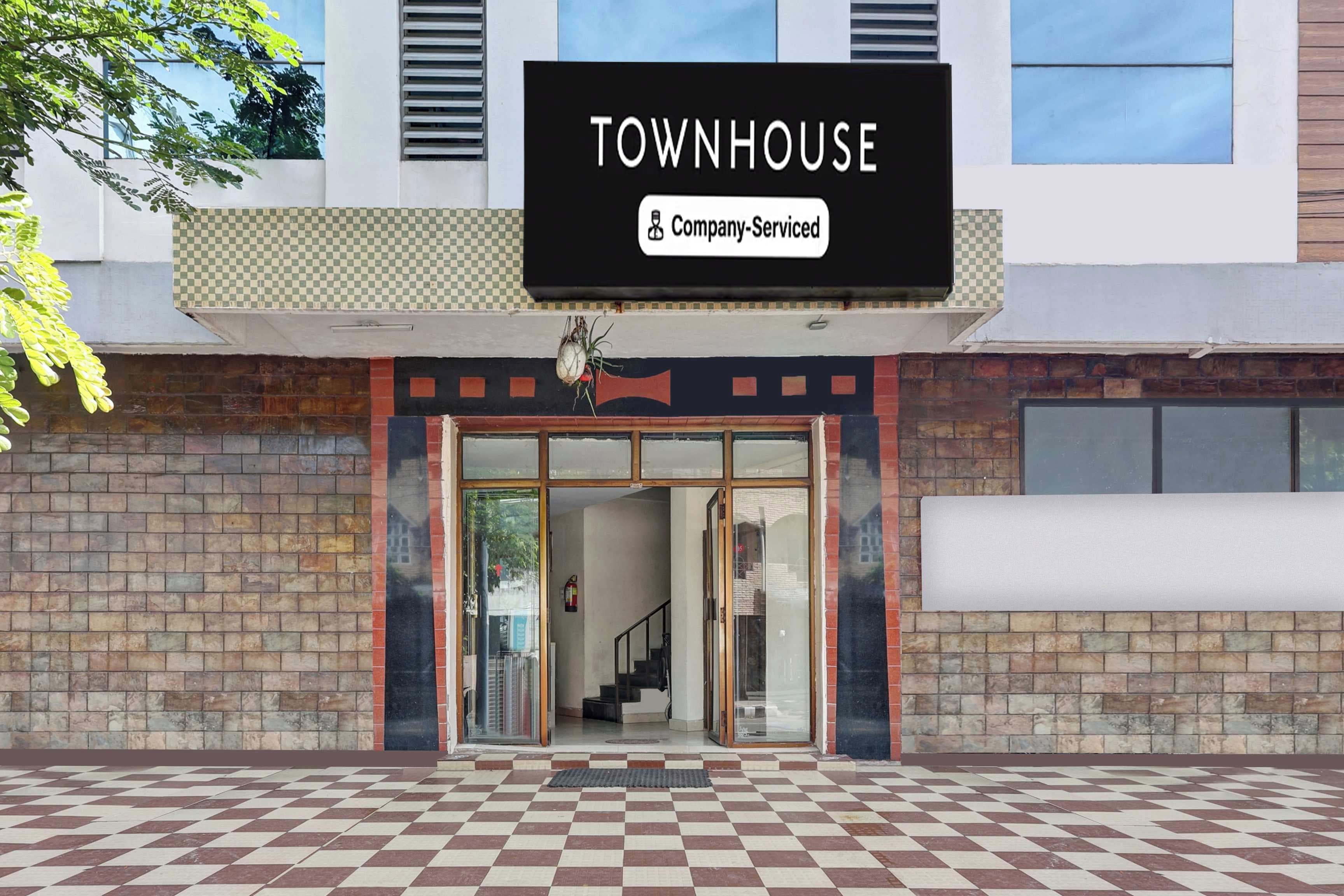 A building with a sign reading 'TOWNHOUSE' and a 'Company-Serviced' label.