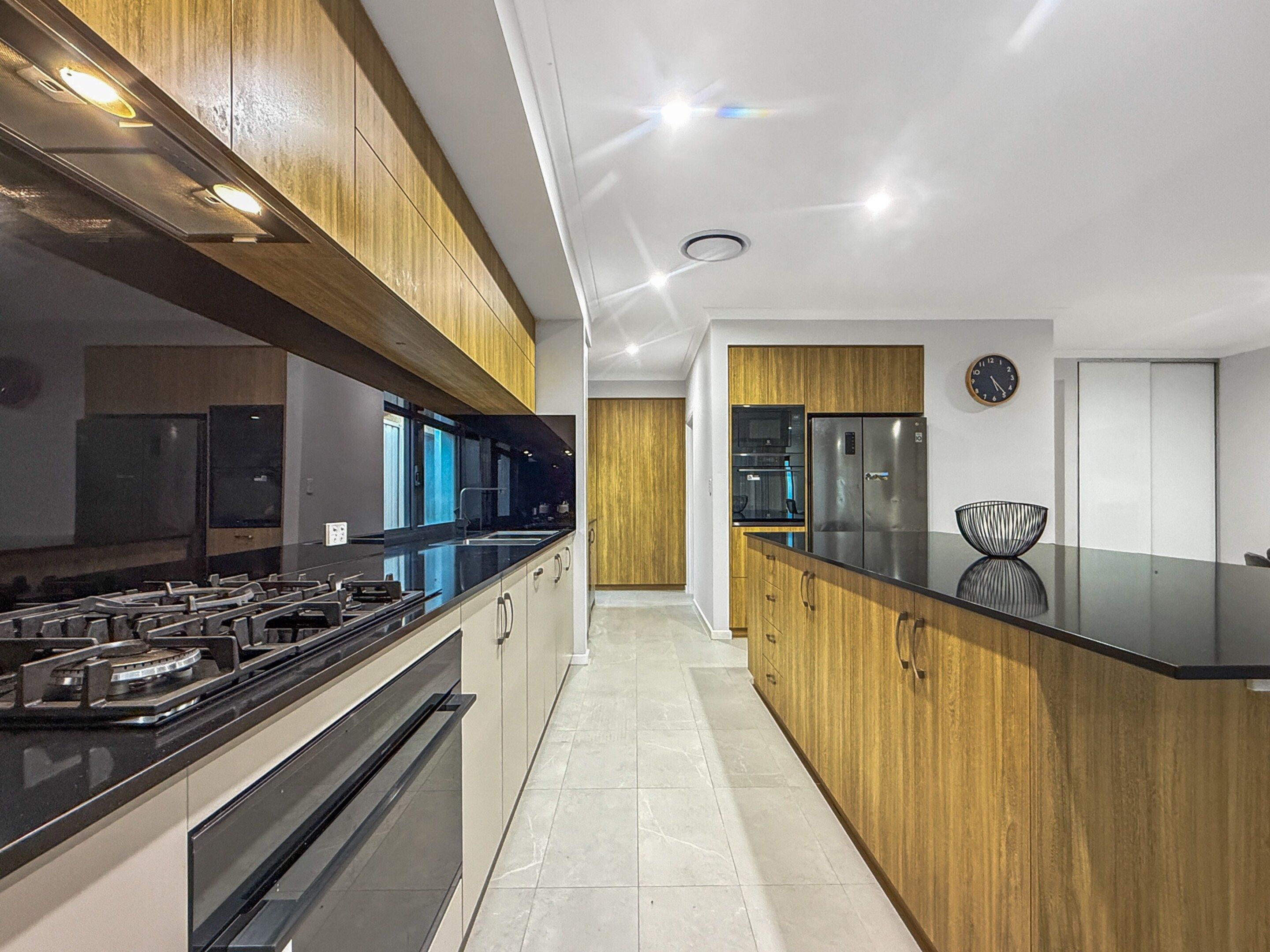 Una cocina moderna con una isla central, electrodomésticos de acero inoxidable y muebles de madera.