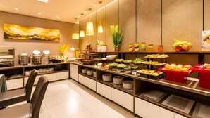 Um buffet de café da manhã moderno com diversas opções de alimentos, incluindo frutas, legumes e doces.