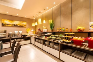 Ein modernes Frühstücksbuffet mit vielfältigen Speisen, darunter Obst, Gemüse und Gebäck.
