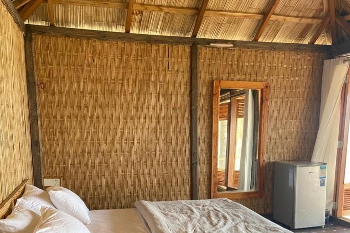 A room with a bed, a small table, and a refrigerator.
