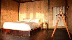 Una habitación con cama, mesita de noche, lámpara colgante y estructura de madera.