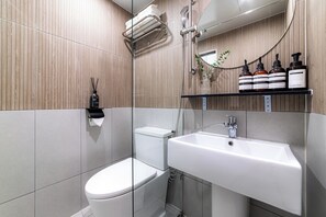 Une salle de bain moderne équipée de toilettes, d’un lavabo et d’une douche.