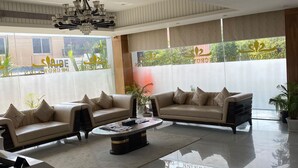Uma sala de estar moderna com dois sofás, uma mesa de centro e um candelabro.