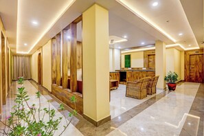 A hotel lobby with a marble floor, wooden paneling, a reception desk, and wicker furniture. - Townhouse Oak Dhanbad Near SSLNT College (Dhanbad)