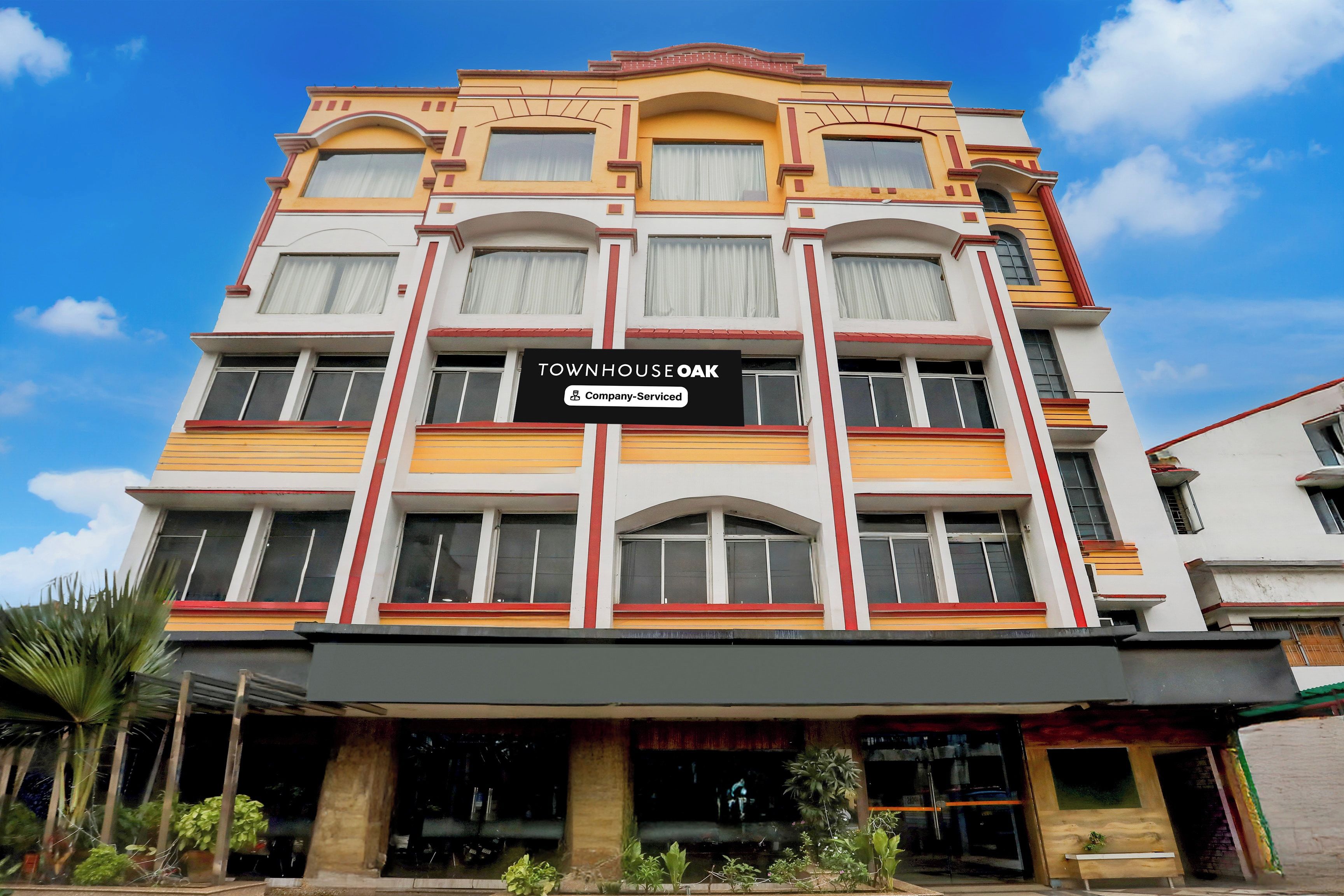A multi-story building with a sign reading 'TOWNHOUSE OAK Company-Served'.