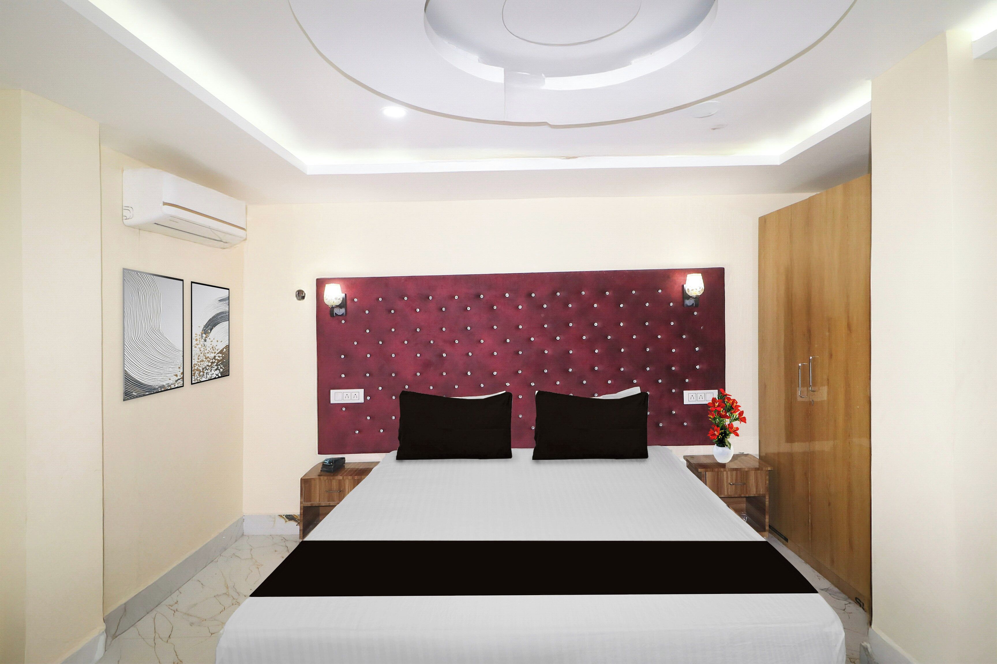 A modern bedroom with a tufted headboard, a large bed, bedside tables, and a wooden wardrobe.