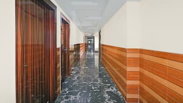 A corridor with wooden doors and a tiled floor.