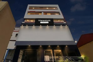 Un edificio de varios pisos con un letrero que dice 'TOWNHOUSE Company-Serviced'.