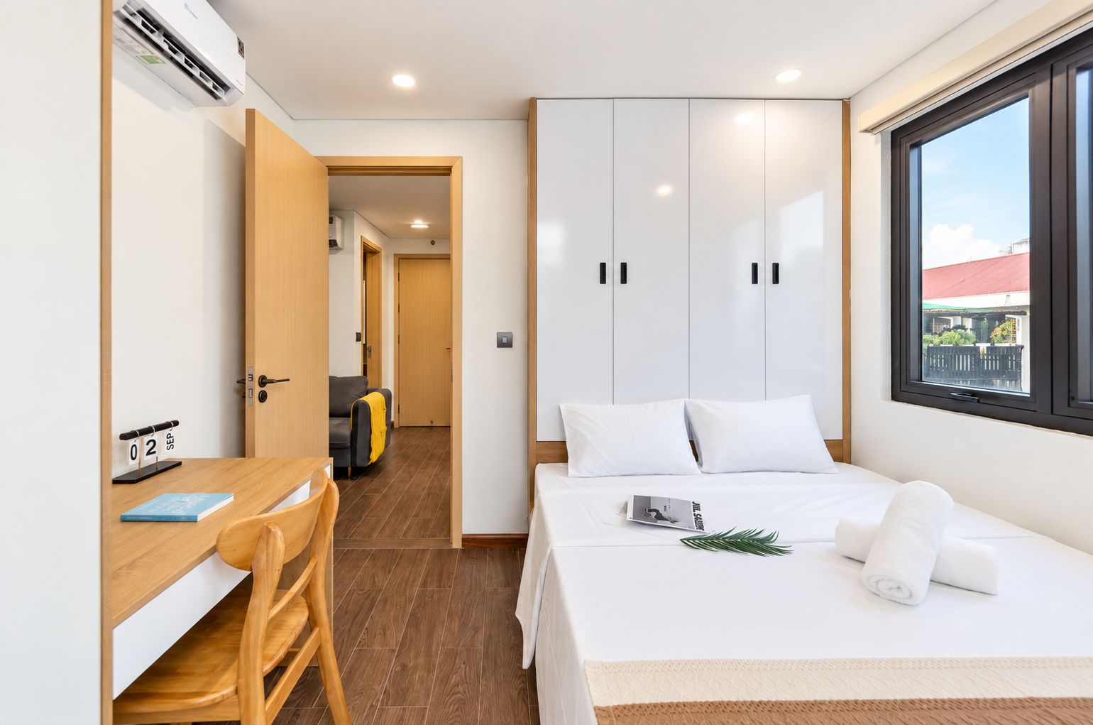 A bedroom with a bed, a desk, and a wardrobe.