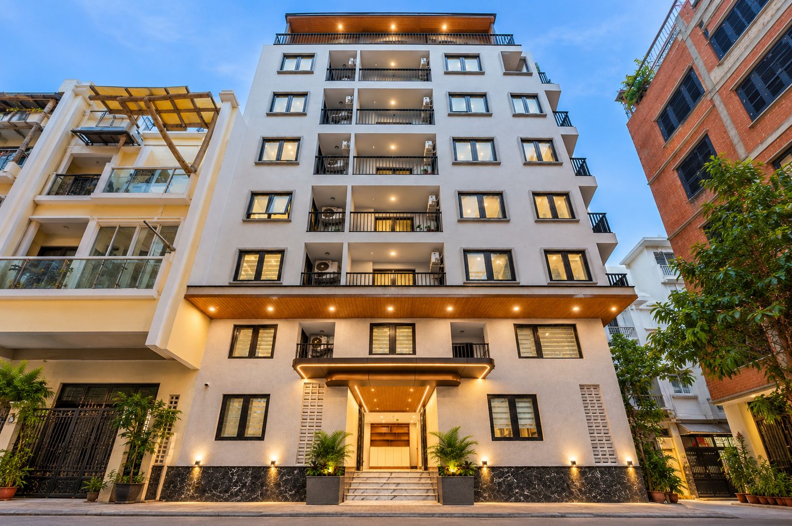A multi-story hotel with a modern facade, balconies, and a well-lit entrance.