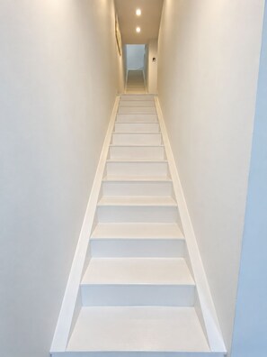 A straight staircase with white steps and handrails, leading to a landing with a door at the top. - 5 BDRM & BATHROOM Pool Villa. Golf Views, 7kms to Patong. Peaceful & private (Tambon Kathu)