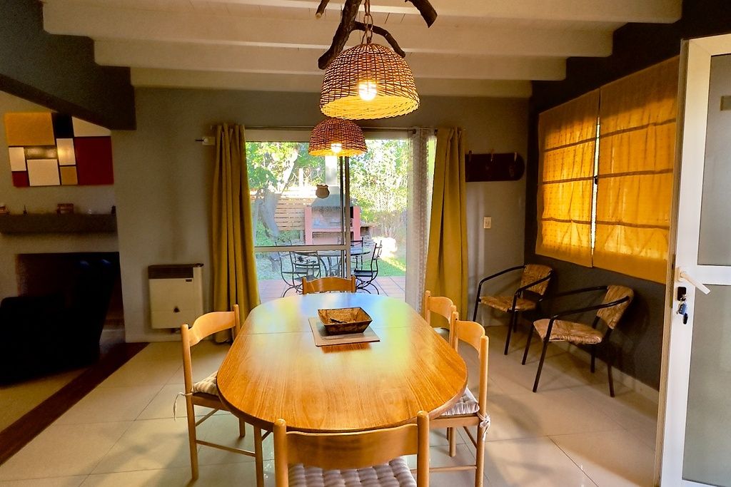 Un espace repas avec une table ronde, des chaises et des lampes suspendues.