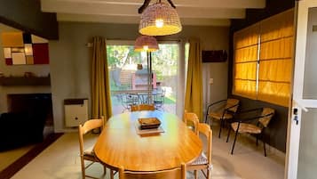 Un espace repas avec une table ronde, des chaises et des lampes suspendues.