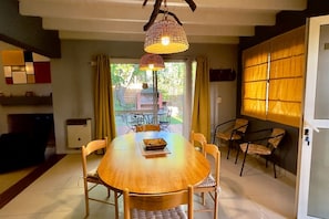 Un espace repas avec une table ronde, des chaises et des lampes suspendues.